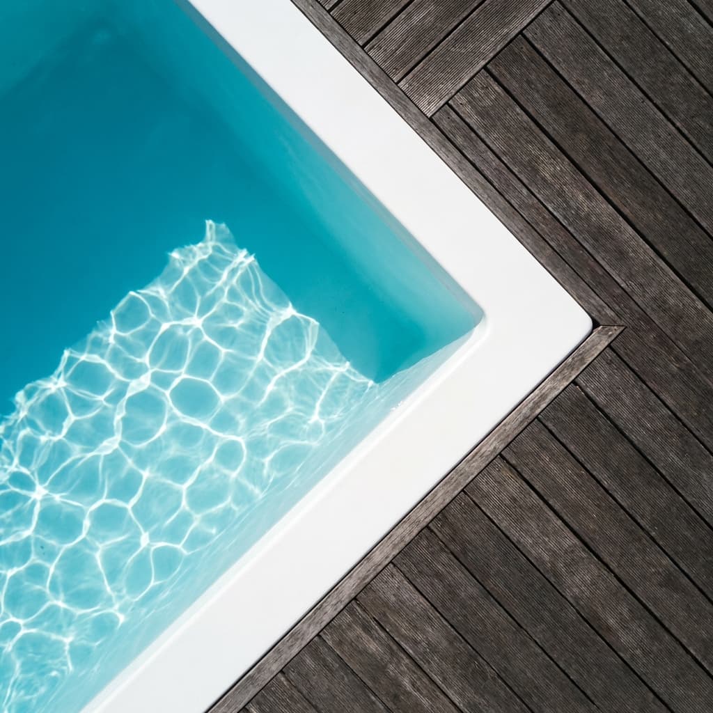 Les avis piscine coque sur la pose et la durabilité Détail minimaliste d'une piscine coque avec eau cristalline et terrasse en bois