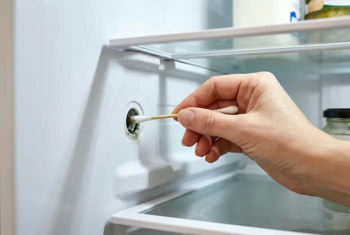 Bloc de glace dans frigo : causes et solutions - Bloc de glace dans frigo : le guide ultime en 4 étapes - Pourquoi votre frigo fait de la glace et comment le réparer ? Nettoyage de l'orifice d'évacuation d'un réfrigérateur avec un coton-tige