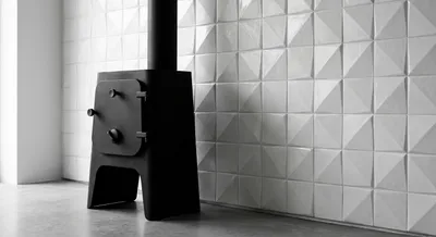 Gros plan contrasté d'un poêle noir sur fond de carreaux géométriques blancs en 3D.