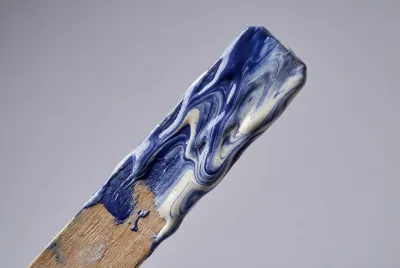 Gros plan sur un bâtonnet de mélange enduit de peinture bleue et blanche