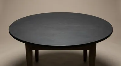Vue minimaliste d'une table ronde ancienne relookée en gris anthracite
