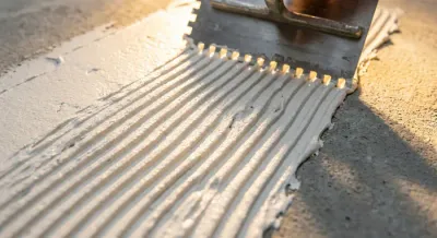 Zoom sur les sillons de colle à carrelage réguliers pour la pose de faïence.