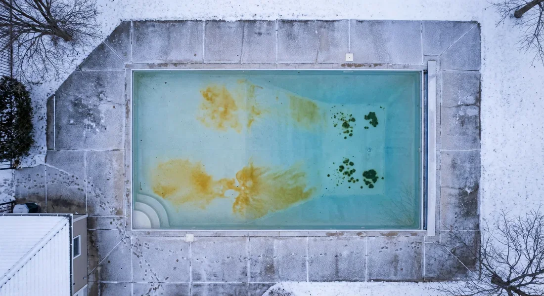 Piscine d'aspect hivernal avec zones de poudre jaune et ocre au fond du bassin.