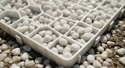 Gros plan de gravier blanc remplissant une plaque de stabilisation alvéolée.