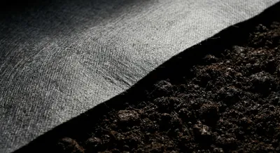 Gros plan iconique sur la texture d'un feutre géotextile de séparation.