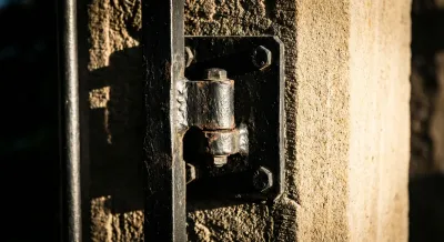 Gros plan iconique sur le gond d'un portail en fer noir et son mécanisme
